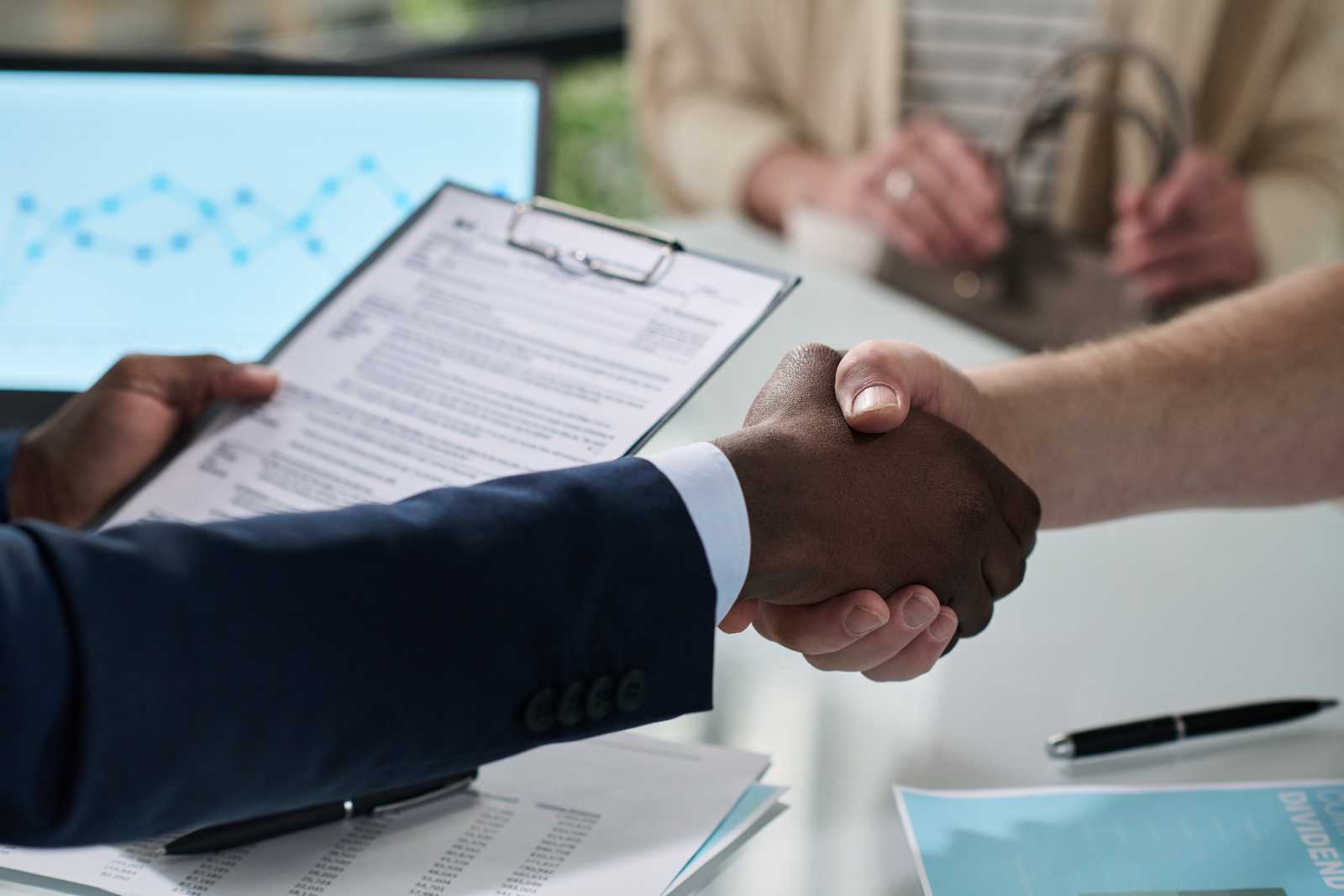 two people shaking hands over a signed agreement, symbolizing successful private lending partnership – h4 services